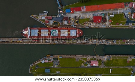 Panama Canal area view, container ship transit, water tanks, composed of locks Royalty-Free Stock Photo #2350375869