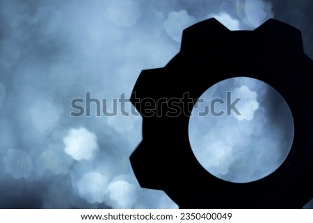 silhouette of a gear wheel with bokeh effect