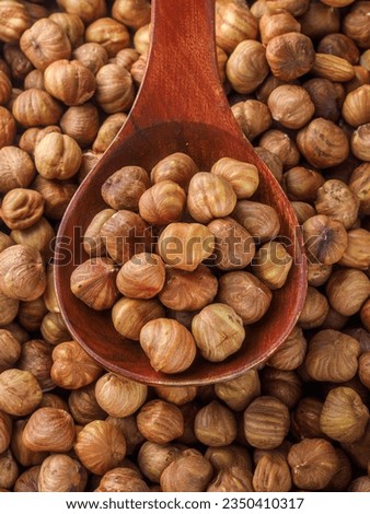 Peeled hazelnuts. Hazelnut kernels lie in wooden spoon. Top view of nuts close-up. Advertising photography for marketplaces or online stores.