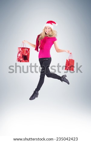 Festive blonde carrying gift bags on vignette background