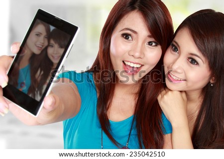 two happy woman take a photo of her self