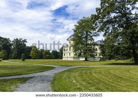 Abstract photo of the castle park on a sunny day with the castle building hidden behind the trees. Beautiful natural wallpaper with a castle in the background. Park, leo, travel