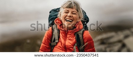 Senior woman living an active lifestyle in her retirement, embarking on a scenic hike and enjoying life to the fullest. This elderly hiker's passion for adventure embraces nature for overall wellness. Royalty-Free Stock Photo #2350437541