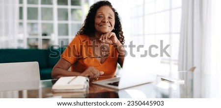 Senior woman managing her business from her home office, using a laptop to work with clients remotely. Experienced woman showing her ability to adapt and thrive in a hybrid business world. Royalty-Free Stock Photo #2350445903