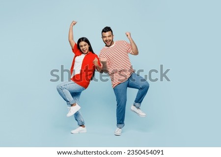 Full body young couple two friends family Indian man woman wear red casual clothes t-shirts together doing winner gesture celebrate clenching fists say yes isolated on plain blue cyan color background Royalty-Free Stock Photo #2350454091