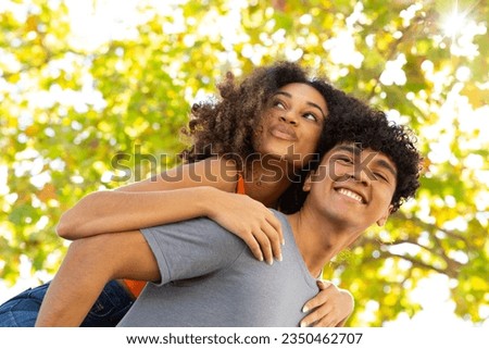 Portrait cheerful young couple giving fun piggyback ride Royalty-Free Stock Photo #2350462707