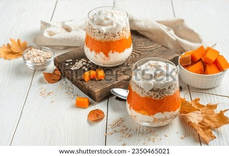 Creamy dessert with pumpkin mousse and cereals on an autumn background. Pumpkin parfait. 