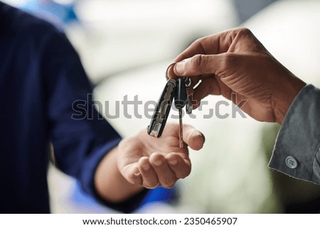 Closeup image of mechanic giving car keys to client after repairing it Royalty-Free Stock Photo #2350465907
