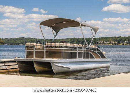 Pontoon boat at private marina dock on freshwater lake. Royalty-Free Stock Photo #2350487465