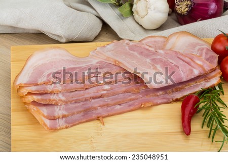 Bacon with rosemary and cherry tomato on the wood table