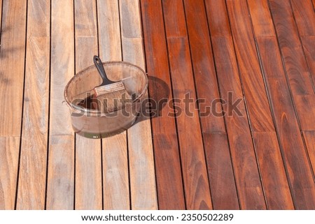 Wood deck refreshing, deck oil bucket with paint brush Royalty-Free Stock Photo #2350502289