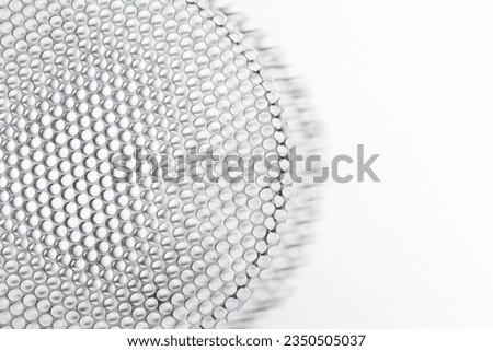 Detail of a grid or round metal platform full of holes. White background..