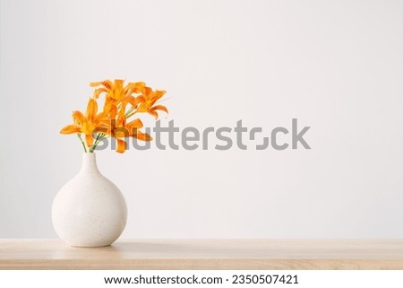 summer flowers in white modern vase on wooden shelf Royalty-Free Stock Photo #2350507421