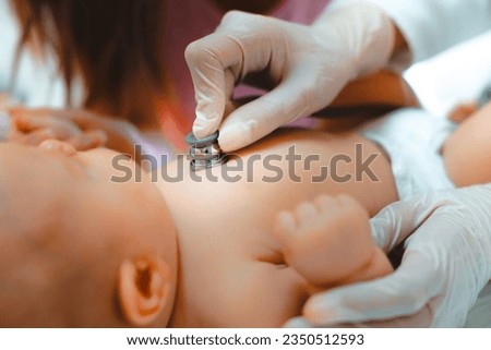 Close up of unrecognizable doctor examining baby with stethoscope in hospital while wearing protective gloves.