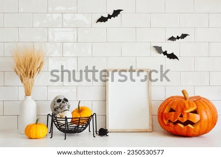 Photo frame mockup with Jack o lantern, pumpkins, skull, vase of dried flowers on table in Scandinavian style interior kitchen