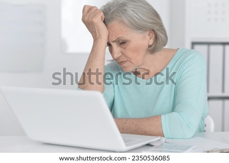 old cute woman with a laptop on a white background.