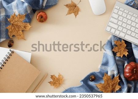 Creating a cozy home office for autumn. Top view photo of copybooks, warm blanket, keyboard, computer mouse, pumpkins, acorns, autumn leaves on pastel beige background with empty space for ad or text