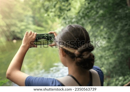 young woman taking photos on her phone, hands with camera close-up, concept of hiking and traveling