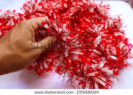 A pile of metalic red and white tinsel garland, iredescent holiday decorations for birthday, wedding, festtivities, christmas, or independent day