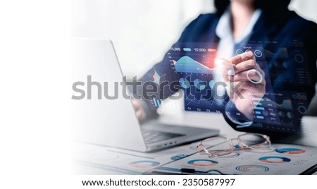 Businesswomen analyzes to chart data business on a visual screen dashboard, technology devices and screens visible in the background, financial planning, market research, and the stock market.