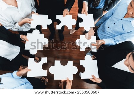 Top view multiethnic business people holding jigsaw pieces and merge them together as effective solution solving teamwork, shared vision and common goal combining diverse talent. Meticulous Royalty-Free Stock Photo #2350588607