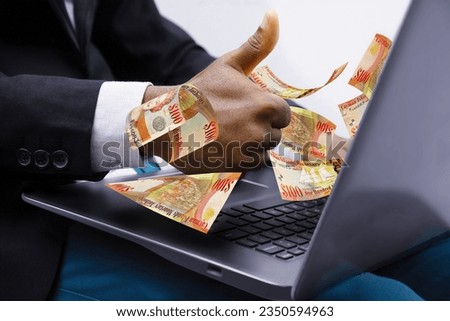 Cayman Islands Dollar notes coming out of laptop with Business man giving thumbs up, Financial concept. Make money on the Internet, working with a laptop