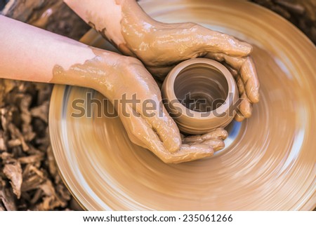 Hands of young potter, was produced on range of pot. Royalty-Free Stock Photo #235061266