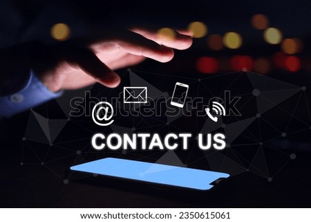 Contact us concept. Businessman hand above smart phone light screen with contact icon email social media chanel online devices. Question information customer services and products inquiry information
