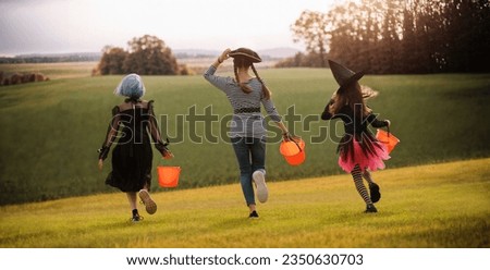 Happy kids are running to Halloween party. Children are wearing carnival costumes. Royalty-Free Stock Photo #2350630703