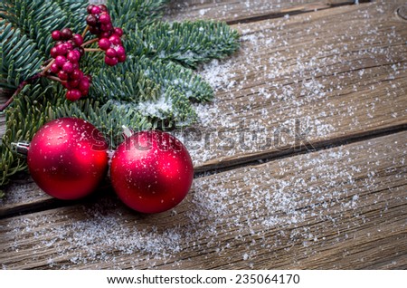 Christmas background with a red ornament, berries and fir in snow