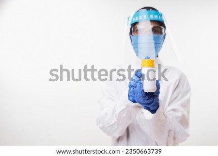 Young Female in medical uniform and protected mask holding Medicine Pills Botles. The concept of health and medical care