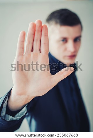 young businessman showing stop sign