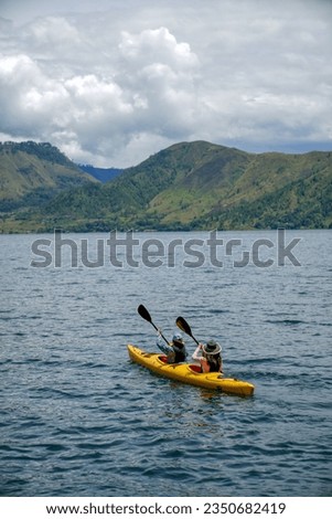 People kayaking in Lake Toba, North Sumatra, Indonesia, The World's Largest Volcanic Lake. Lake Toba is now become a famous travel destination. Its landscape, people and culinary have the best moment.