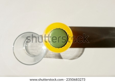 Lemonade Bottle and a Glass on table view from above. Closeup Flat lay Photography for Banner, Promotion, Ptinting, Poster. Fresh and juicy non-alcoholic Summer drink.