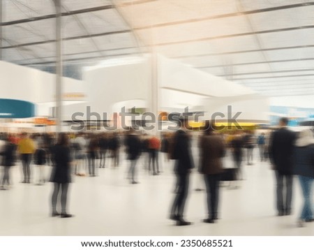 blurred business people walking at a trade fair, conference or walking in a modern hall, motion speed blur, wide panoramic banner
