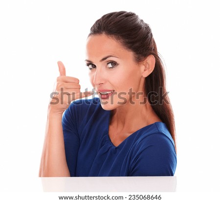 Fashionable female smiling and making a call sign with hand while looking at you front view in white background