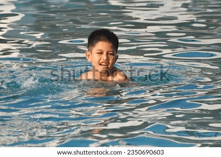 A boy enjoying the day in the swimming pool 