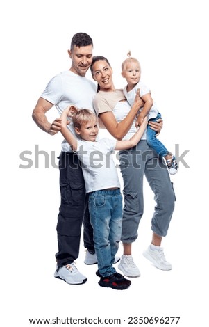 Family with two small children. Young mom, dad, son and daughter are hugging and laughing. Love and tenderness. Full height. Isolated on a white background. Vertical. Royalty-Free Stock Photo #2350696277
