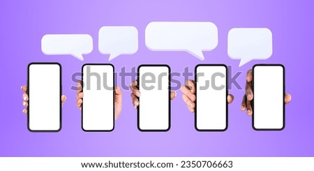 Hands of five diverse men and women showing smartphones with mock up screens and speech bubbles above them over purple background. Social media, communication and advertising concept Royalty-Free Stock Photo #2350706663