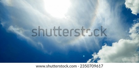 Blue sky and clouds with bright shining sun.