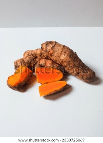 close-up of bunch of fresh whole and sliced ​​turmeric isolated on white background.