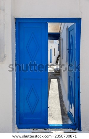 Traditional, blue wooden door of a typical house in Cyclades, half open to the patio of the house, in Koufonisi island, Cyclades, Greece, Europe