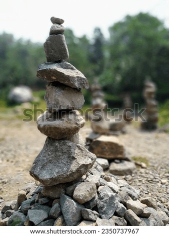 river stones arranged like a monument beside the river
