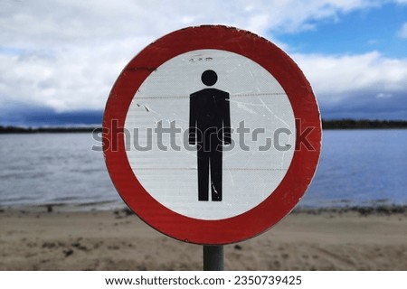 Nature without people. Pedestrians prohibited sign on bank of river. Negative impact of man on planet and fight against environmental pollution. Restricted area. No entry.