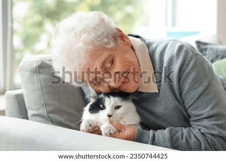 Senior woman with cute cat resting at home Royalty-Free Stock Photo #2350744425