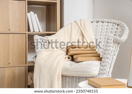 Comfortable armchair with books in living room