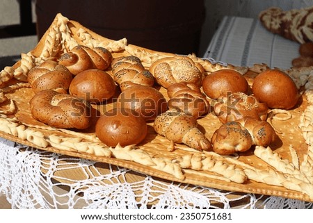   Delicious bakery products of the new crop: fragrant pastries sprinkled with poppy seeds and sesame seeds on a decorative tray                             