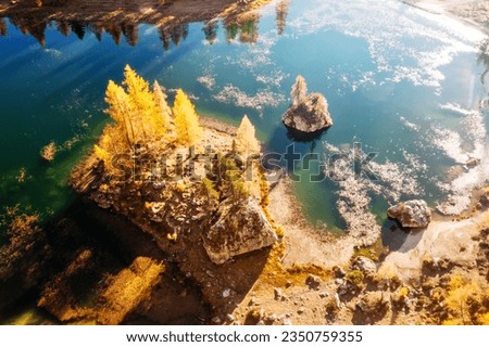 Drone flight over Federa Lake in sunrise time. Autumn mountains landscape with Lago di Federa and bright orange larches in the Dolomite Apls, Cortina D'Ampezzo, South Tyrol, Dolomites, Italy Royalty-Free Stock Photo #2350759355