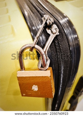 a padlock to secure clothes in a yellow suitcase while on vacation