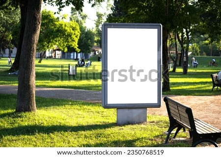 White vertical advertising poster on the grass. Blank banner in the park. Billboard in the city center mock up. LightPoster. Empty billboard idea concept. Copy space, text area. Outdoor. Royalty-Free Stock Photo #2350768519